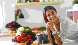 Young woman standing near desk in the kitchen .